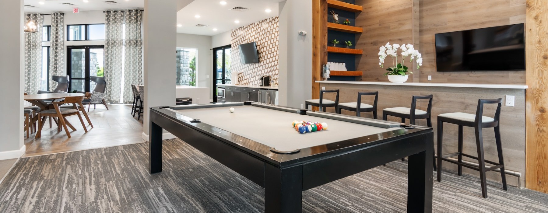 a clubroom with a tv, pool table and chairs